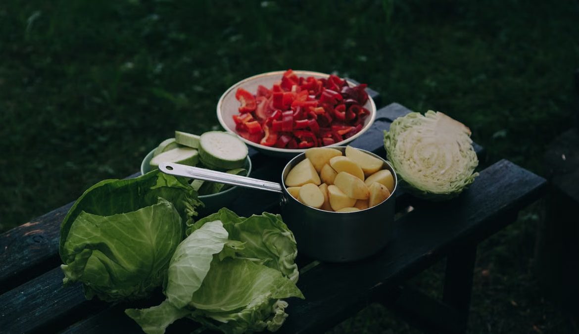 Freshly chopped vegetables on an outdoor table, perfect for a healthy meal.
